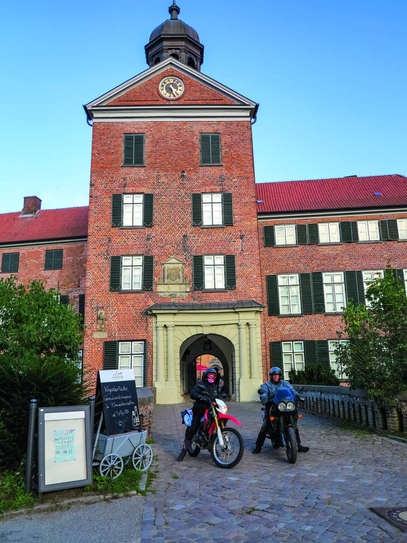 Backsteinernes Gutshaus mit davor abgestellten Motorrädern Backsteinernes Gutshaus mit davor abgestellten Motorrädern